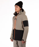 Man wearing a beige and black jacket with orange accents on a white background