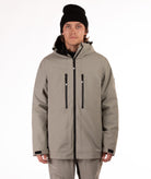 Person wearing a beige jacket with black zippers on a white background