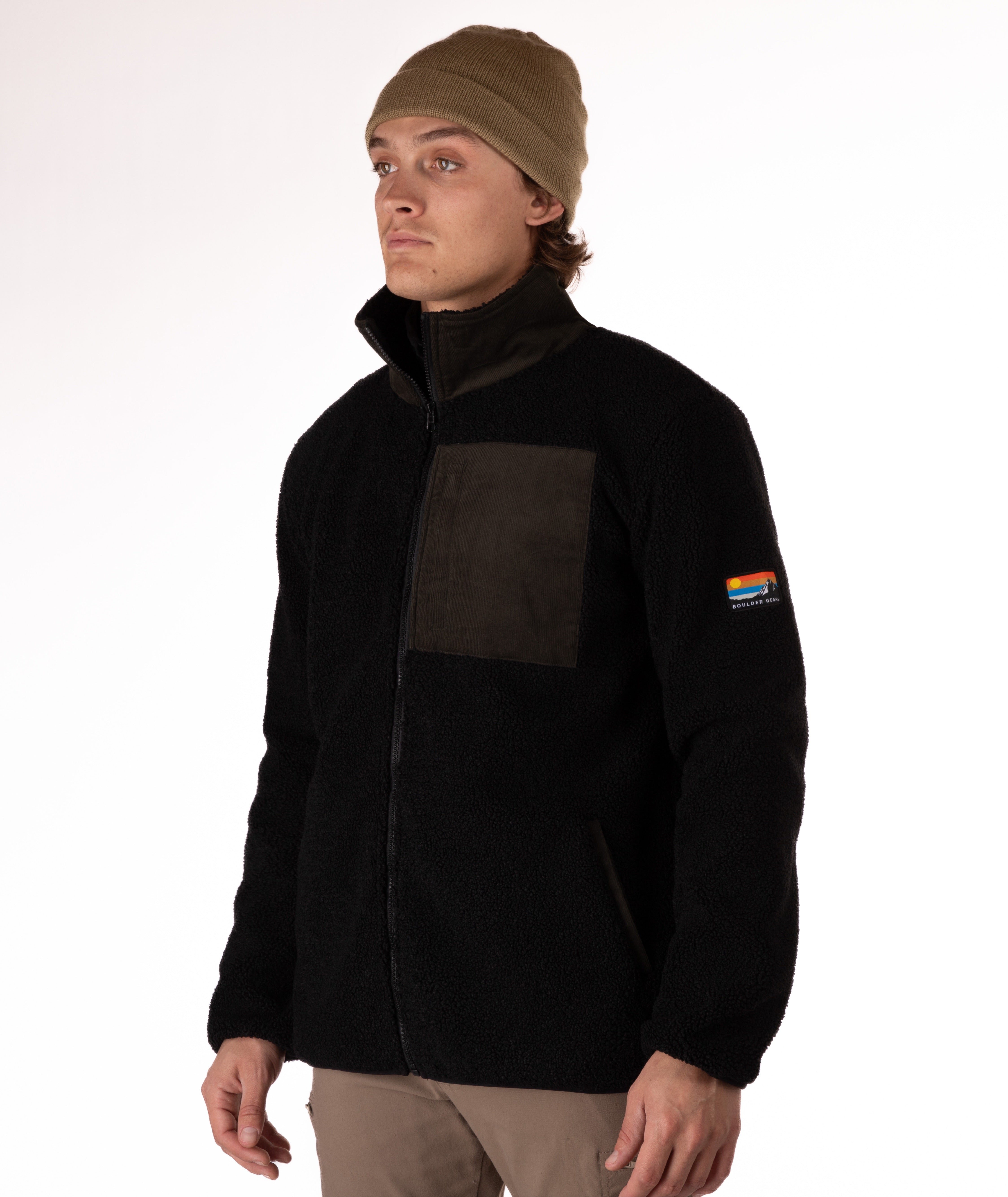 Man wearing a black fleece jacket with a green chest pocket and collar on a white background