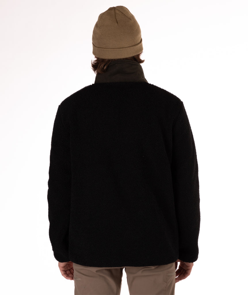 back of man wearing a black fleece jacket with a green collar on a white background