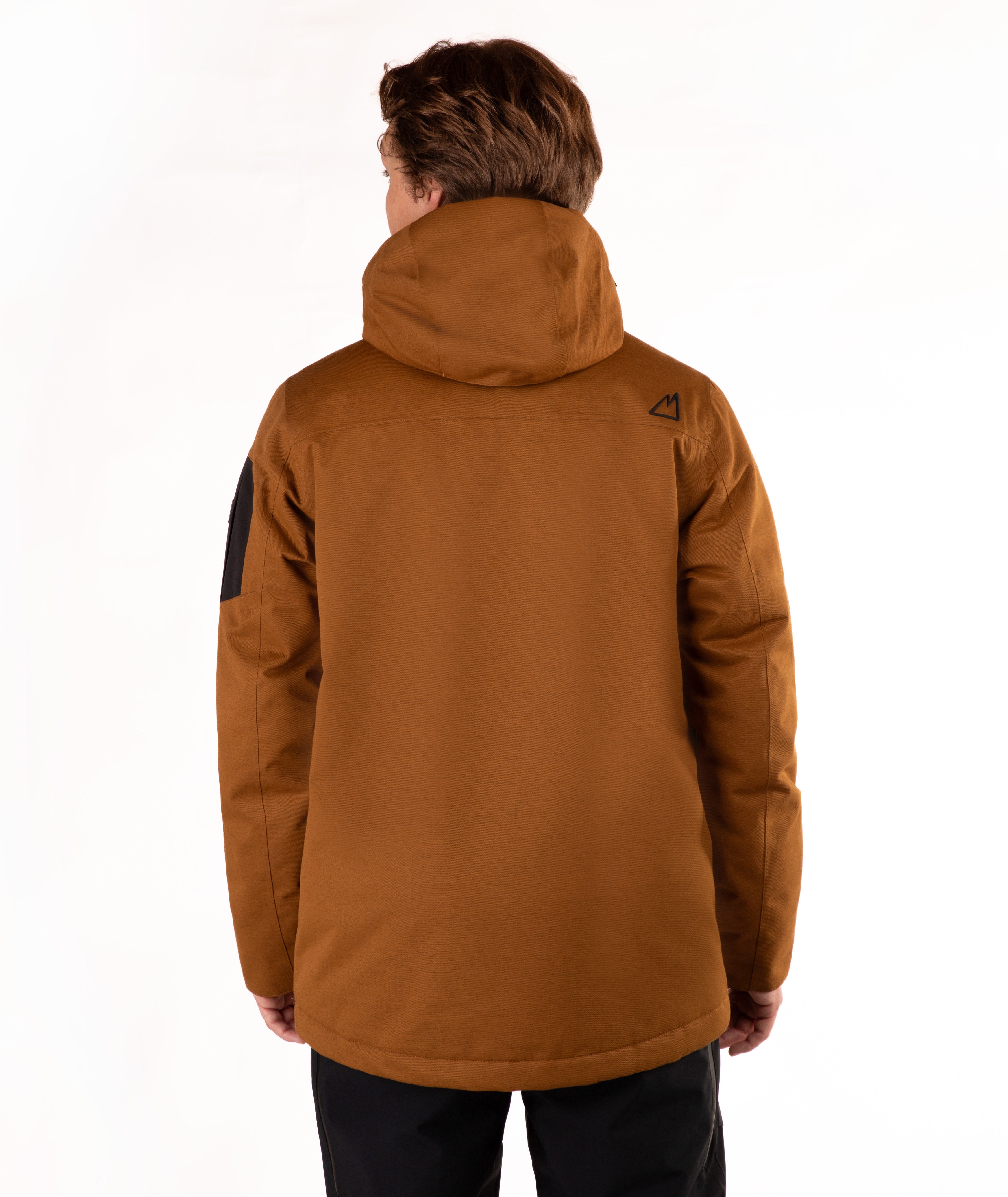 A person viewed from the back wearing a hooded insulated jacket in a warm camel-brown color, with black pants, against a plain white studio background.