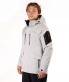 A man wearing a light gray hooded ski jacket with black accents on the chest, sleeves, and hood, posed against a solid white studio background.