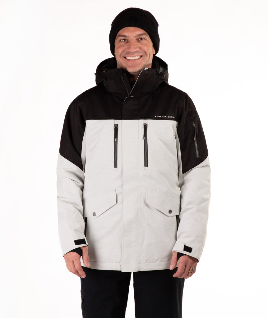 Man wearing a black and light gray jacket with a visible brand logo on a white background
