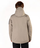 A person shown from the back wearing a light taupe hooded jacket and dark pants against a plain white studio background.
