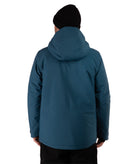 A person shown from the back wearing a dark teal hooded jacket and a black beanie against a plain white studio background.