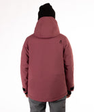 Person wearing a maroon jacket with black zippers and a brand logo on a white background