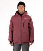 Person wearing a maroon jacket with black zippers and a brand logo on a white background