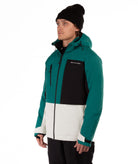 Man wearing a teal, black, and white jacket with a visible brand logo on a white background