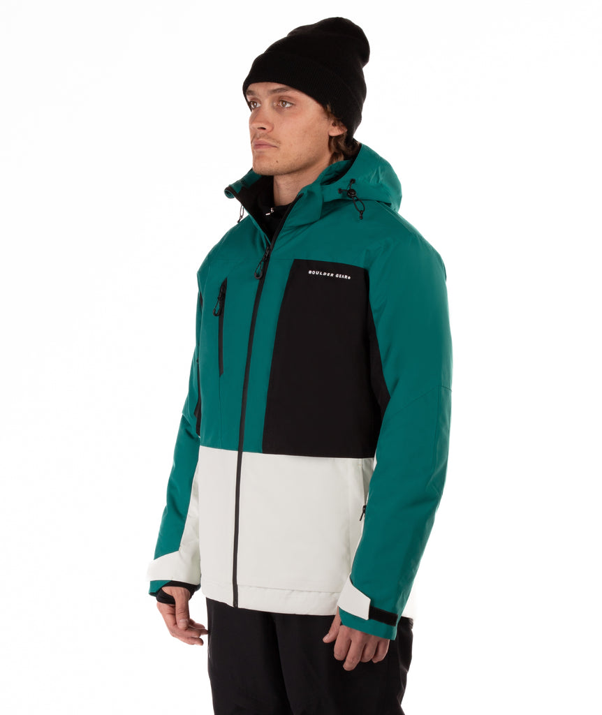 Man wearing a teal, black, and white jacket with a visible brand logo on a white background