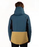 A person shown from the back wearing a color-blocked hooded jacket. The jacket is primarily teal blue on the upper portion and sleeves, with black side panels and a mustard yellow lower panel.
