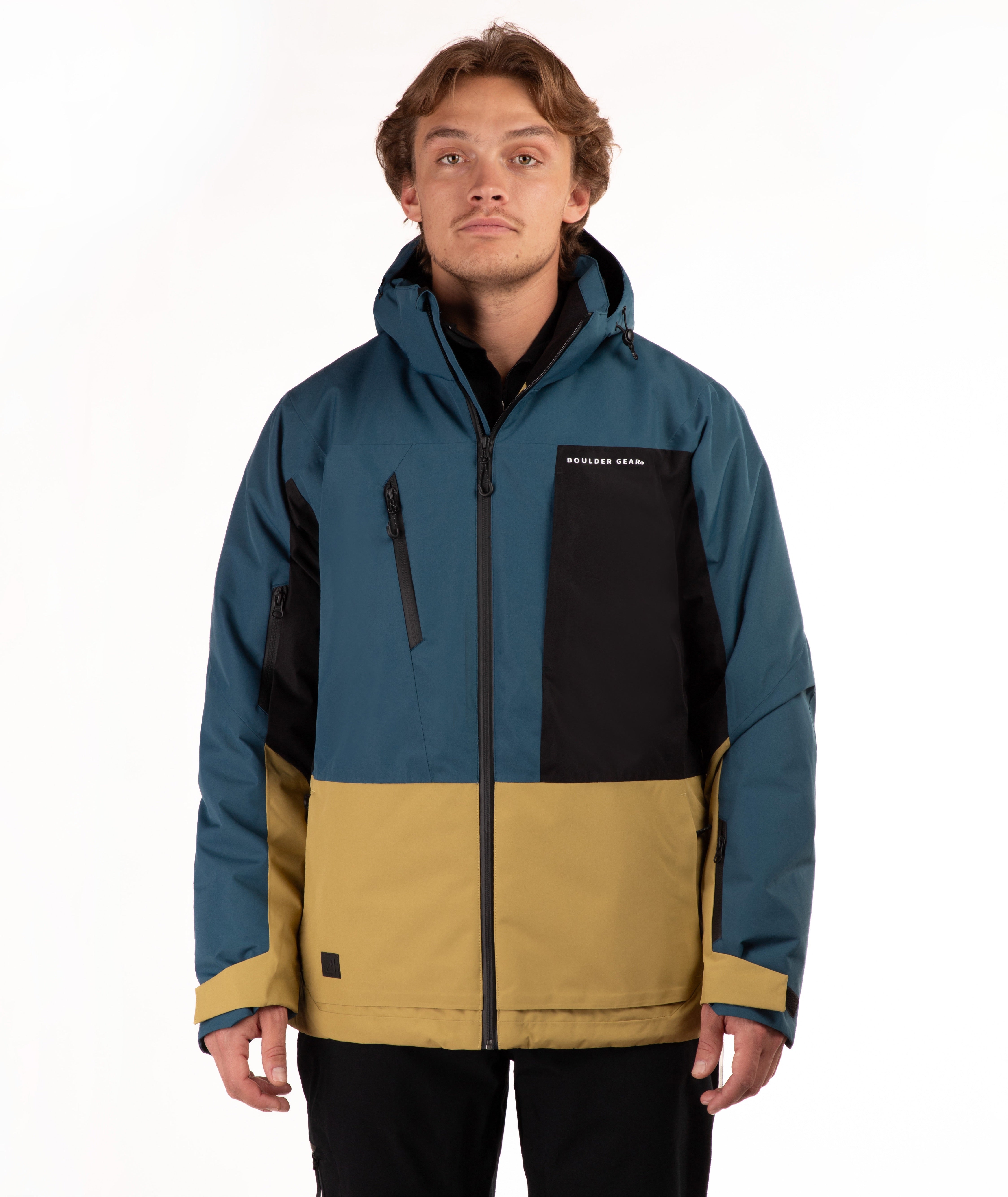 A man wearing a color-blocked outdoor jacket, featuring teal blue, black, and mustard yellow sections, photographed against a plain white studio background.