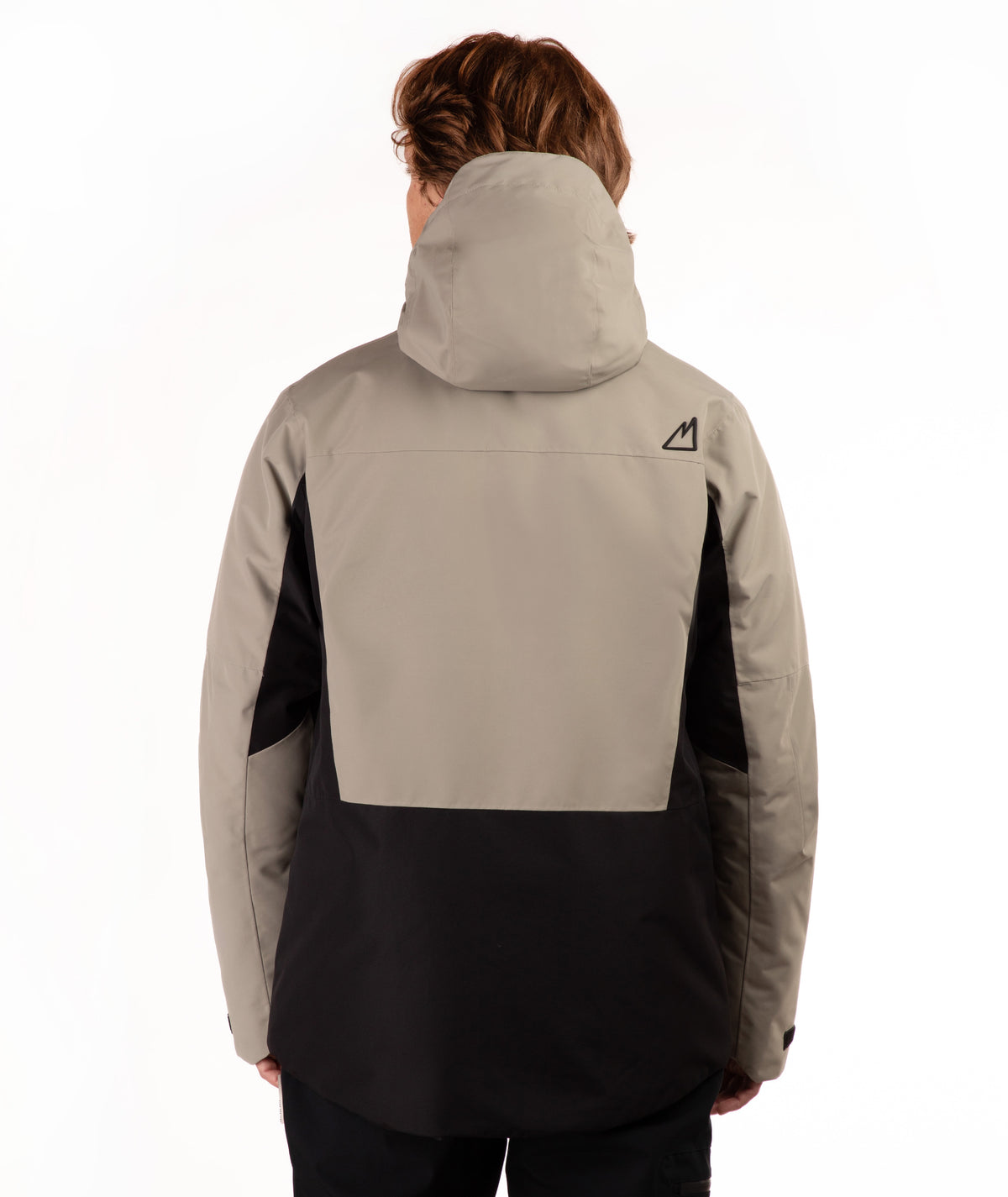 A person shown from the back wearing a colorblock hooded jacket, featuring a light taupe upper section and black lower section, against a plain white background.