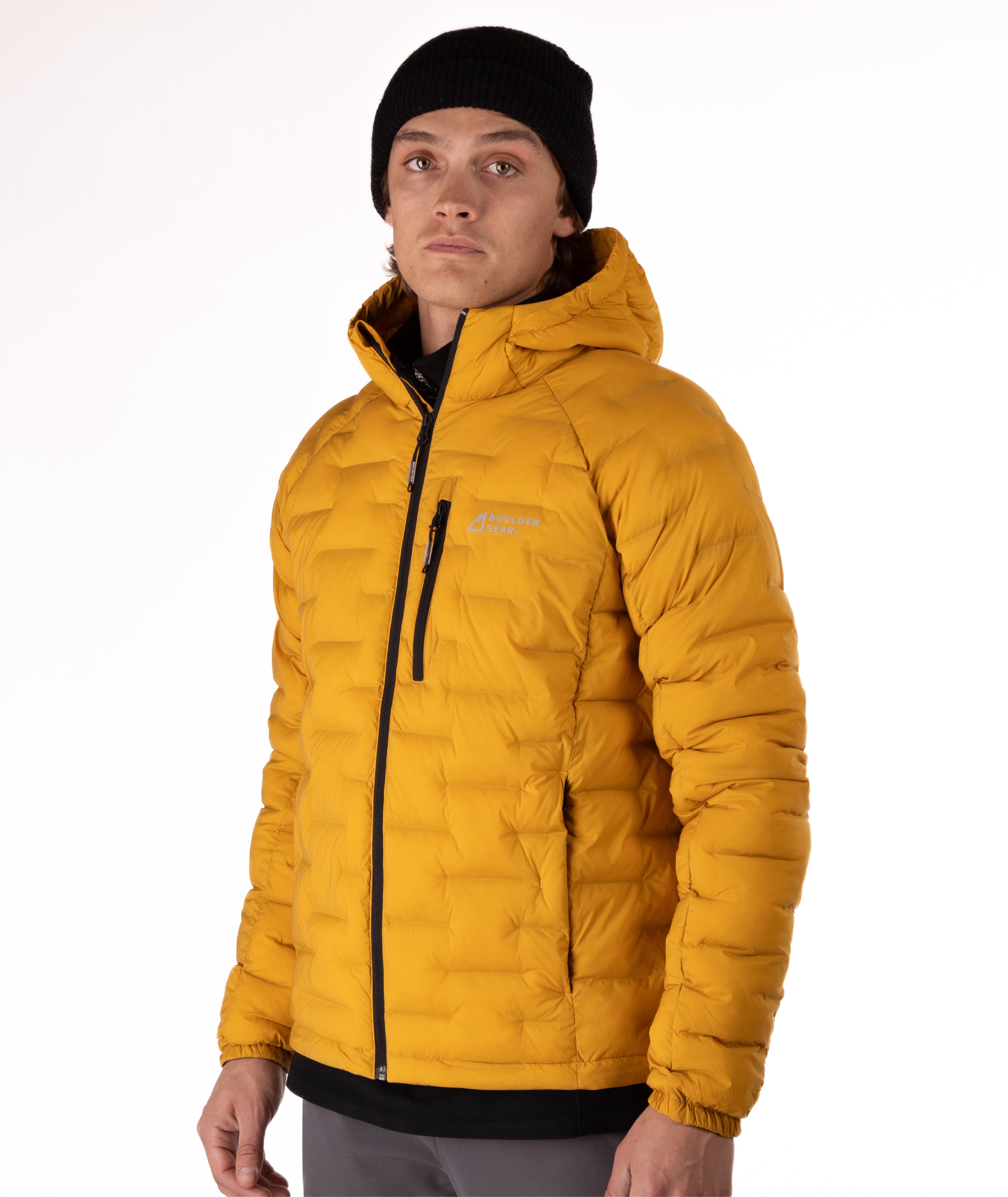 Person wearing a mustard yellow puffer jacket with a black zipper on a white background