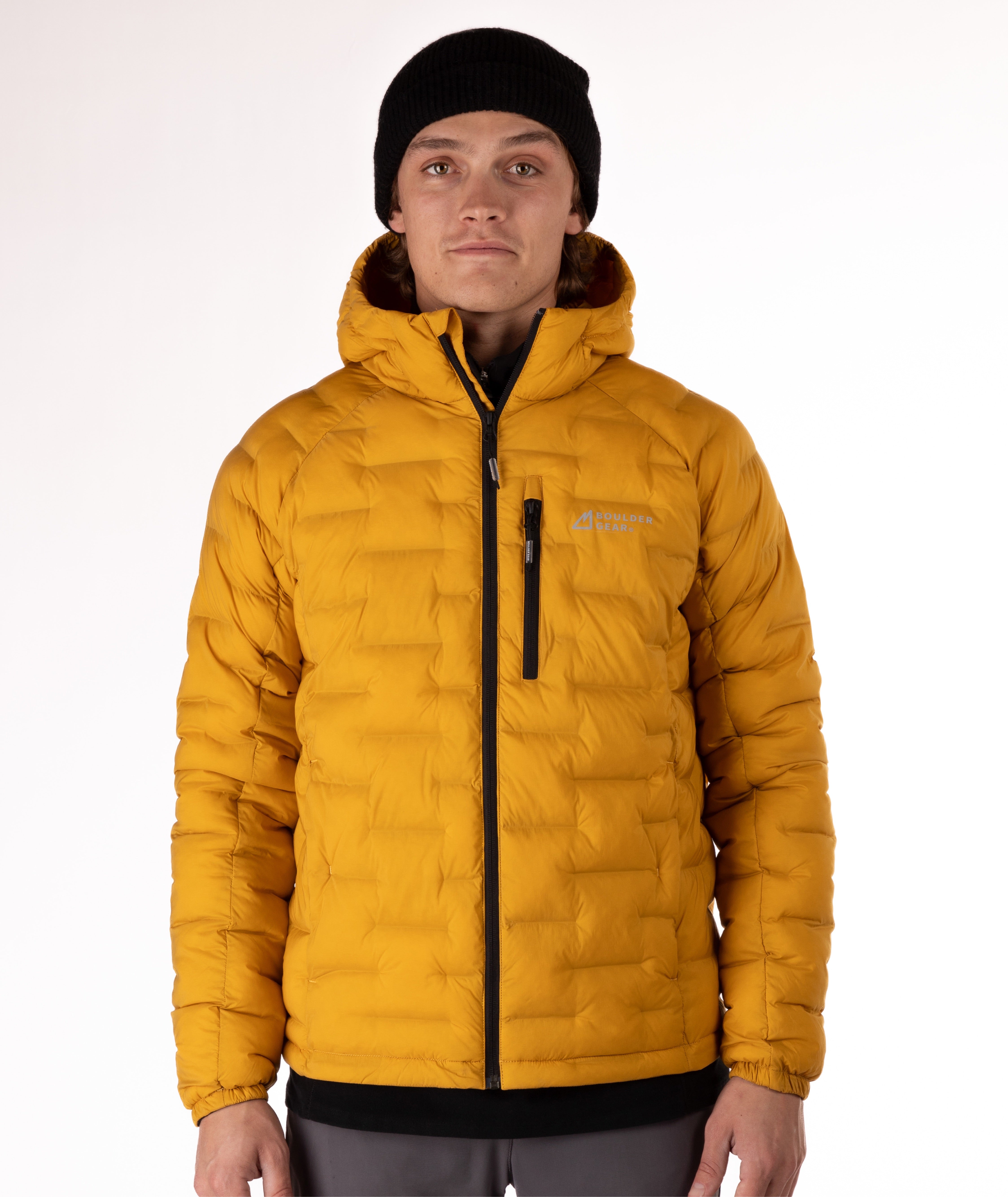 Person wearing a mustard yellow puffer jacket with a black zipper on a white background