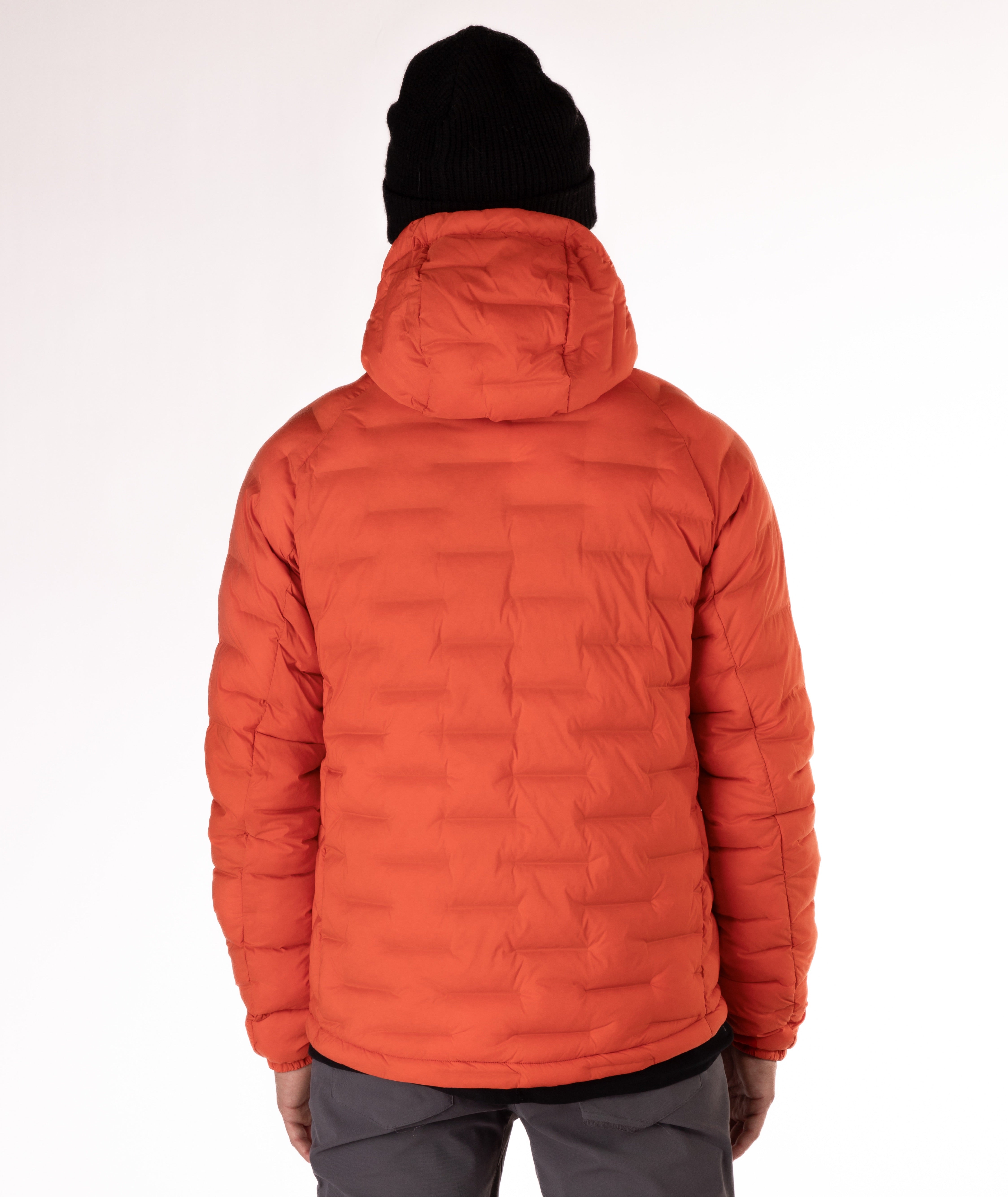 Man wearing a orange puffer jacket with black zippers and a brand logo on a white background