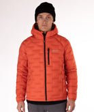 Man wearing a orange puffer jacket with black zippers and a brand logo on a white background