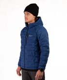 Man wearing a blue puffer jacket with black zippers and a brand logo on a white background