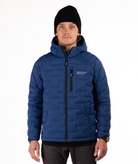 Man wearing a blue puffer jacket with black zippers and a brand logo on a white background