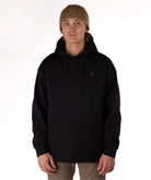 Person wearing a black softshell hoodie on a white background