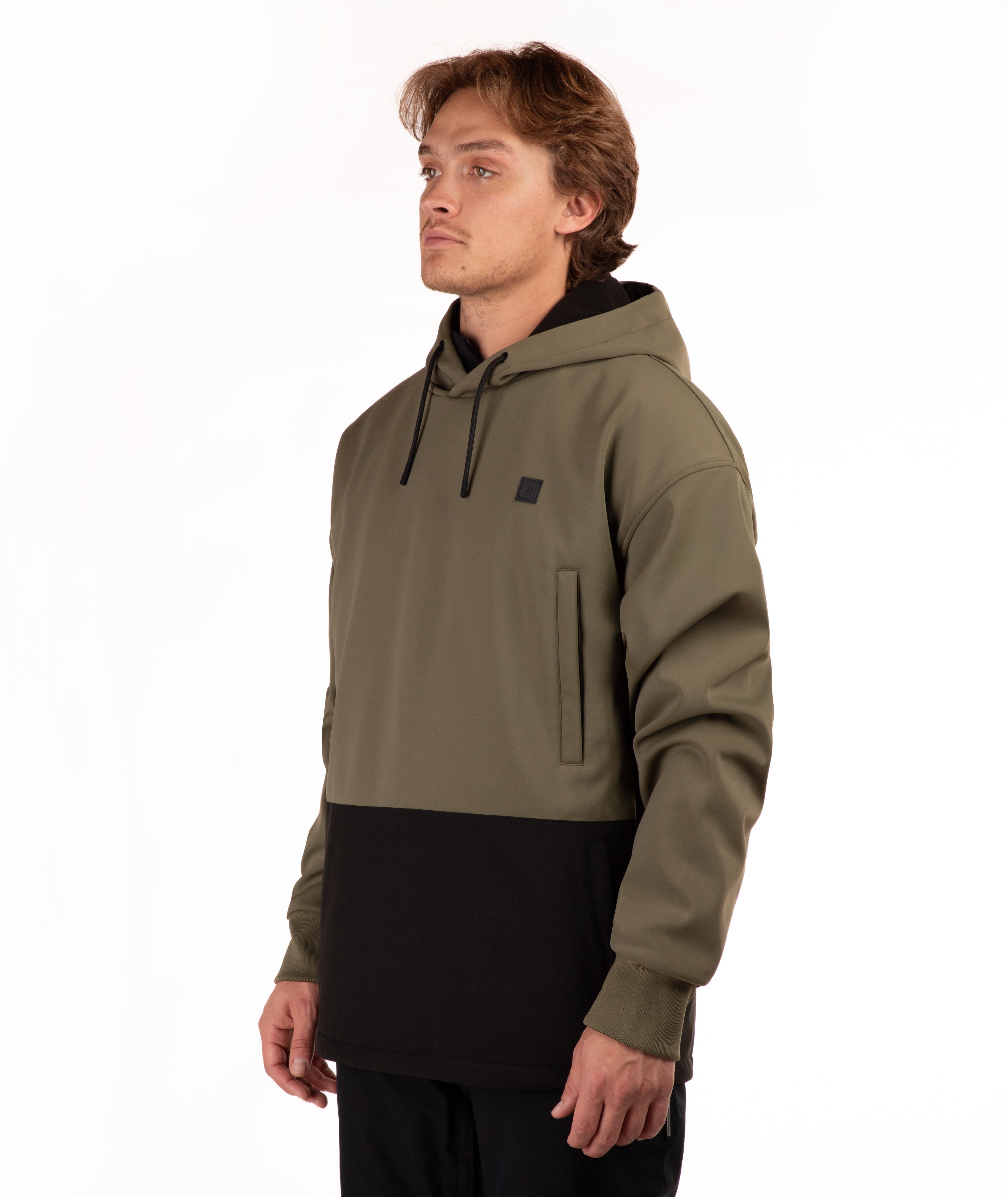 A man wearing a color-blocked pullover hoodie with an olive green upper section and a black lower section, standing against a plain white background.