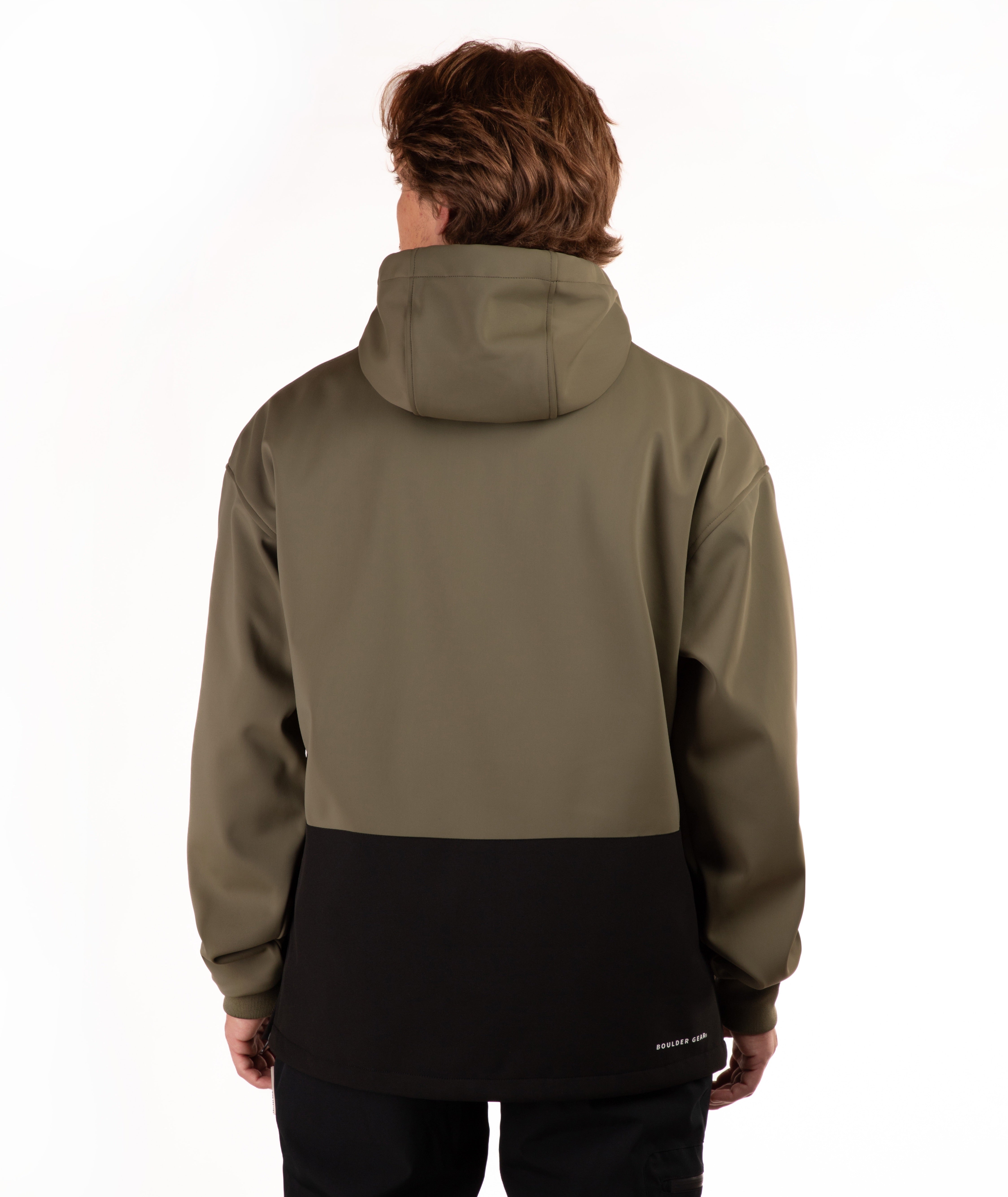 A man viewed from behind wearing a colorblock hooded jacket with an olive green upper section and a black lower panel, set against a plain white studio background.