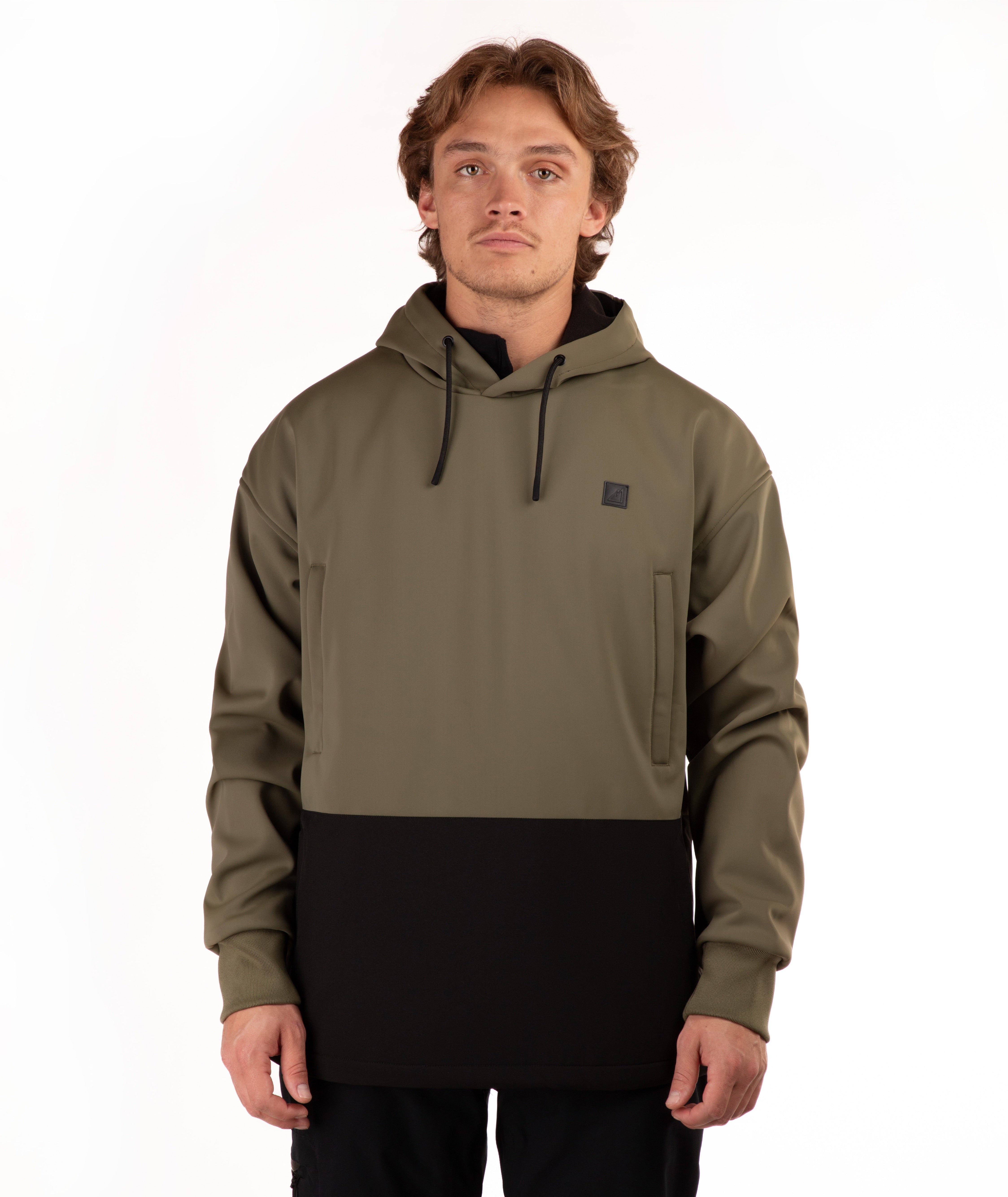 A man wearing a color-blocked pullover hoodie with an olive green upper section and a black lower section, standing against a plain white background.
