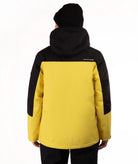 A person shown from the back wearing a colorblock ski jacket in yellow and black, paired with a black beanie and black pants, against a plain white background.