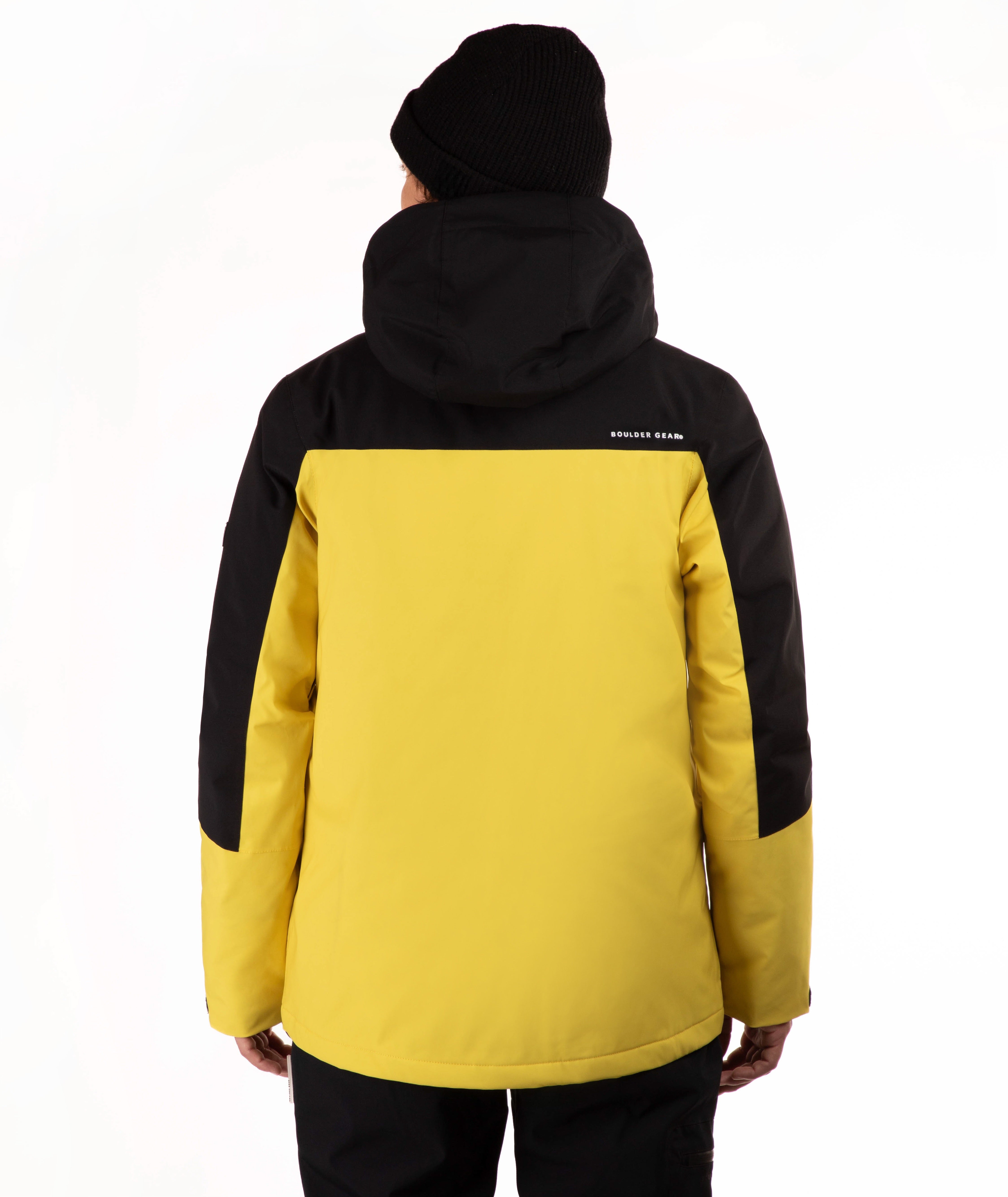 A person shown from the back wearing a colorblock ski jacket in yellow and black, paired with a black beanie and black pants, against a plain white background.