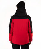 A person shown from the back wearing a red and black hooded puffer jacket with black sleeves and a black beanie against a plain white background.