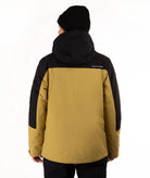 A person shown from the back wearing a color-blocked ski jacket in mustard yellow and black, along with a black beanie, against a plain white studio background.