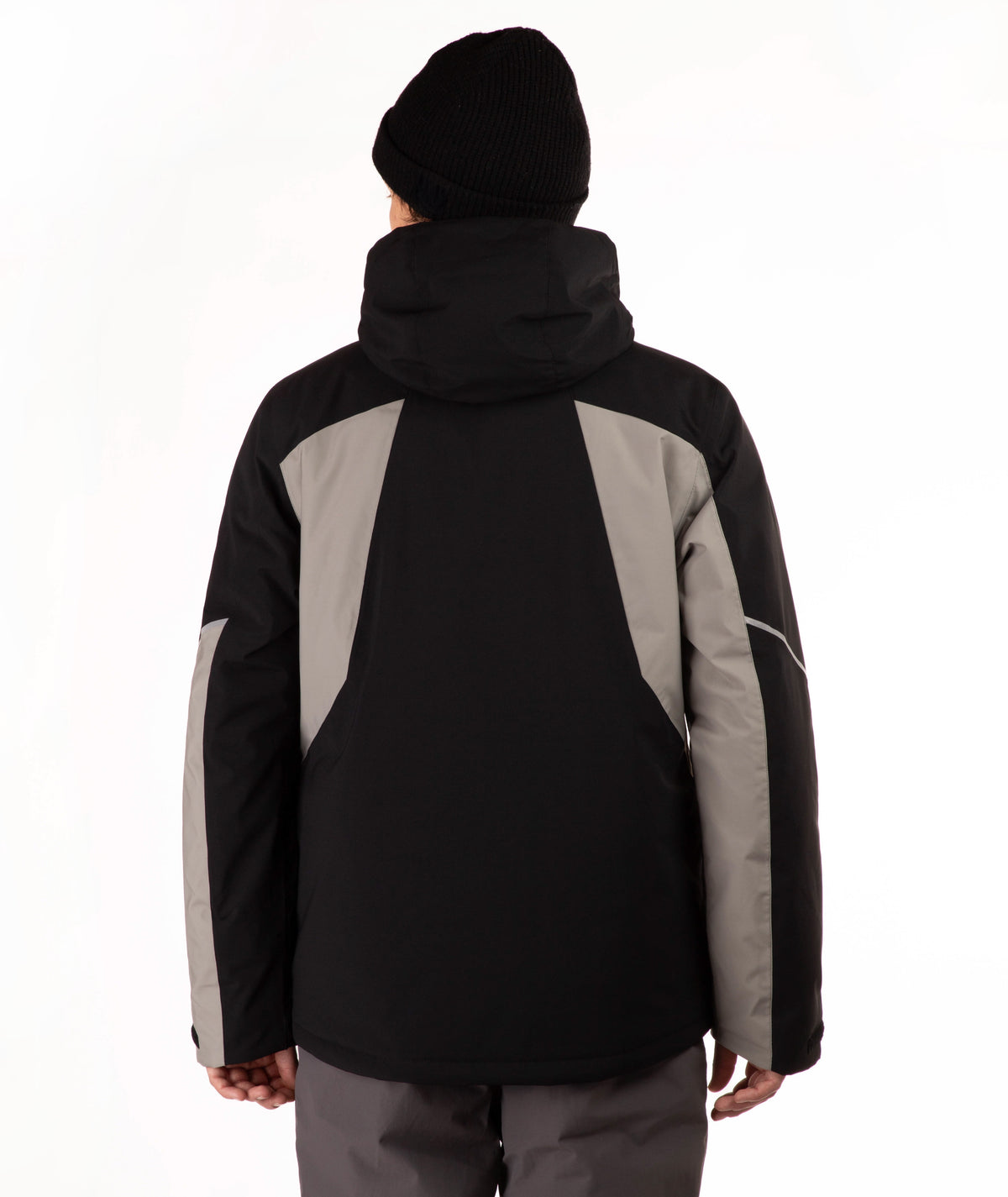 A person shown from the back wearing a black and gray hooded jacket, a black beanie, and gray pants against a plain white studio background.