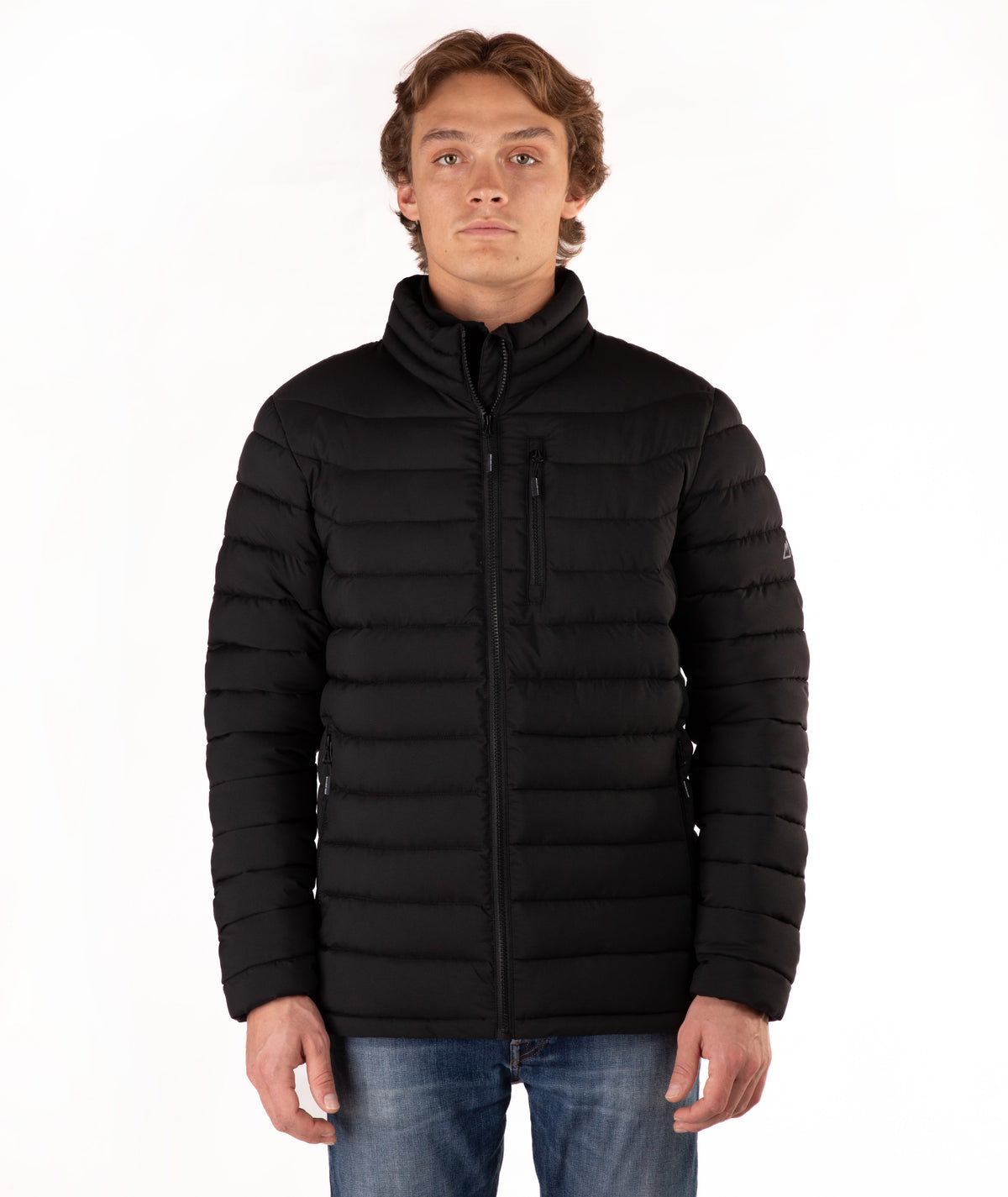 A man wearing a black puffer jacket with a stand-up collar and zippered front, paired with blue jeans, photographed against a plain white background.