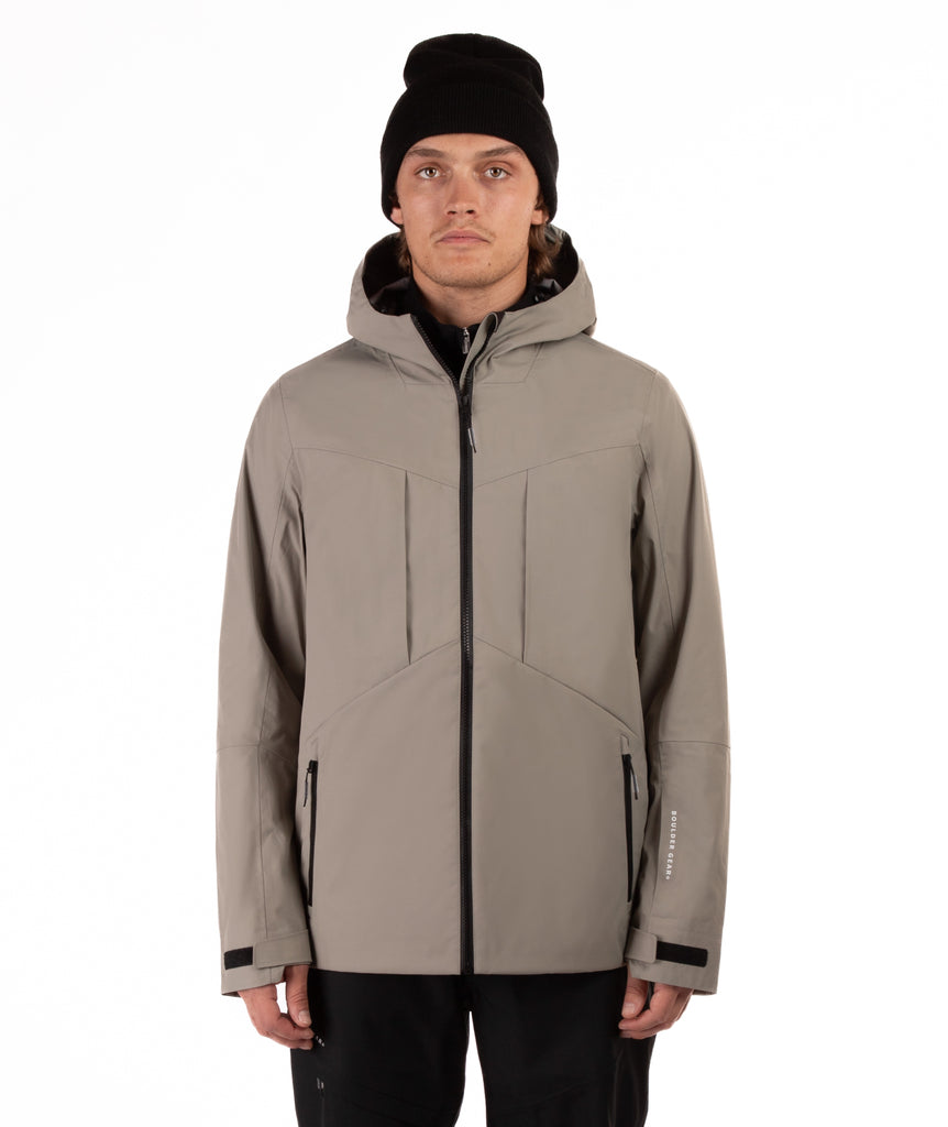 Man wearing a beige jacket with black accents on a white background