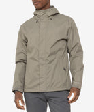 Person wearing a beige rain jacket on a white background