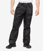 Black rain pants worn by a person on a white background