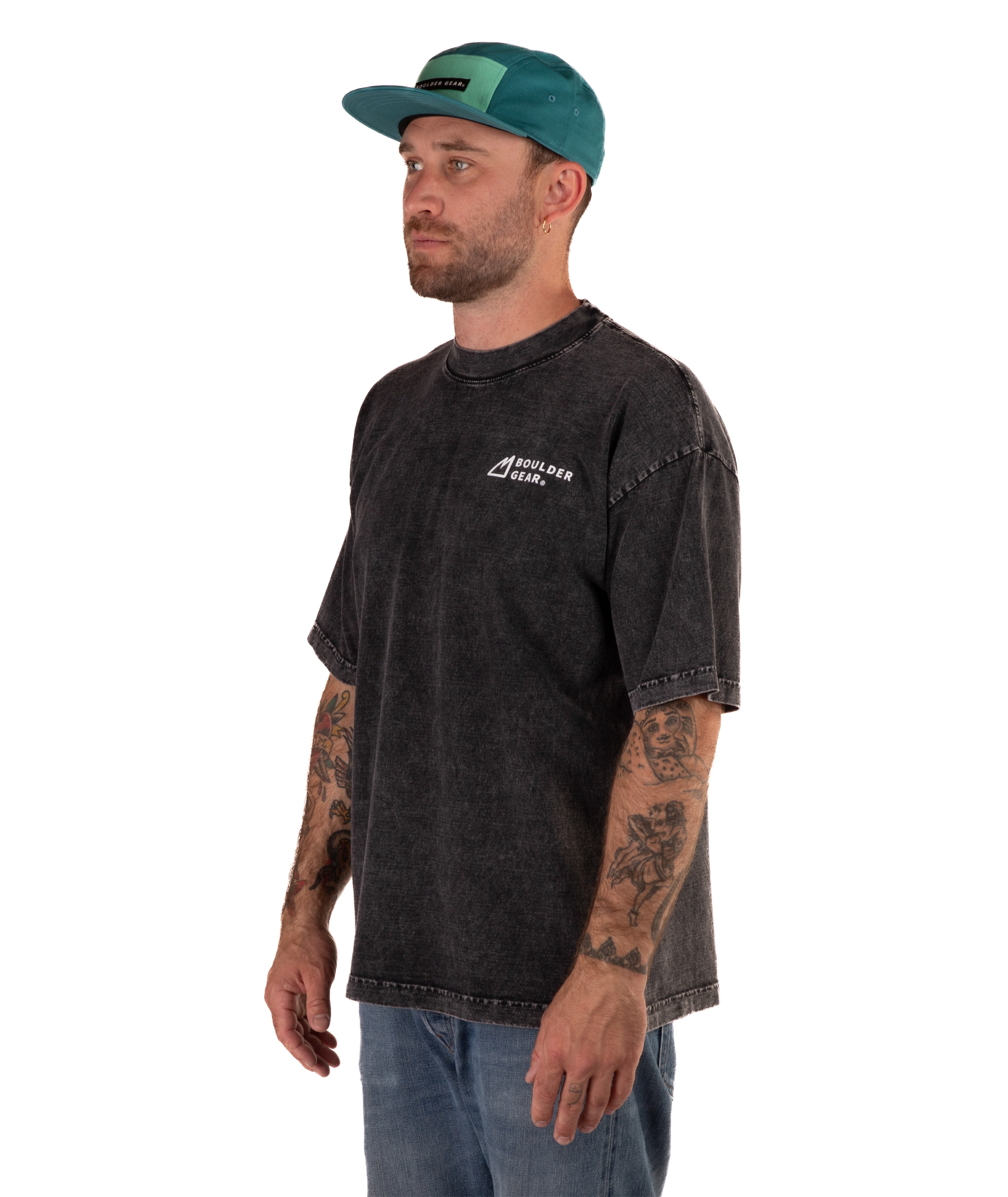 Man wearing a faded black t-shirt with a logo and a green cap on a white background