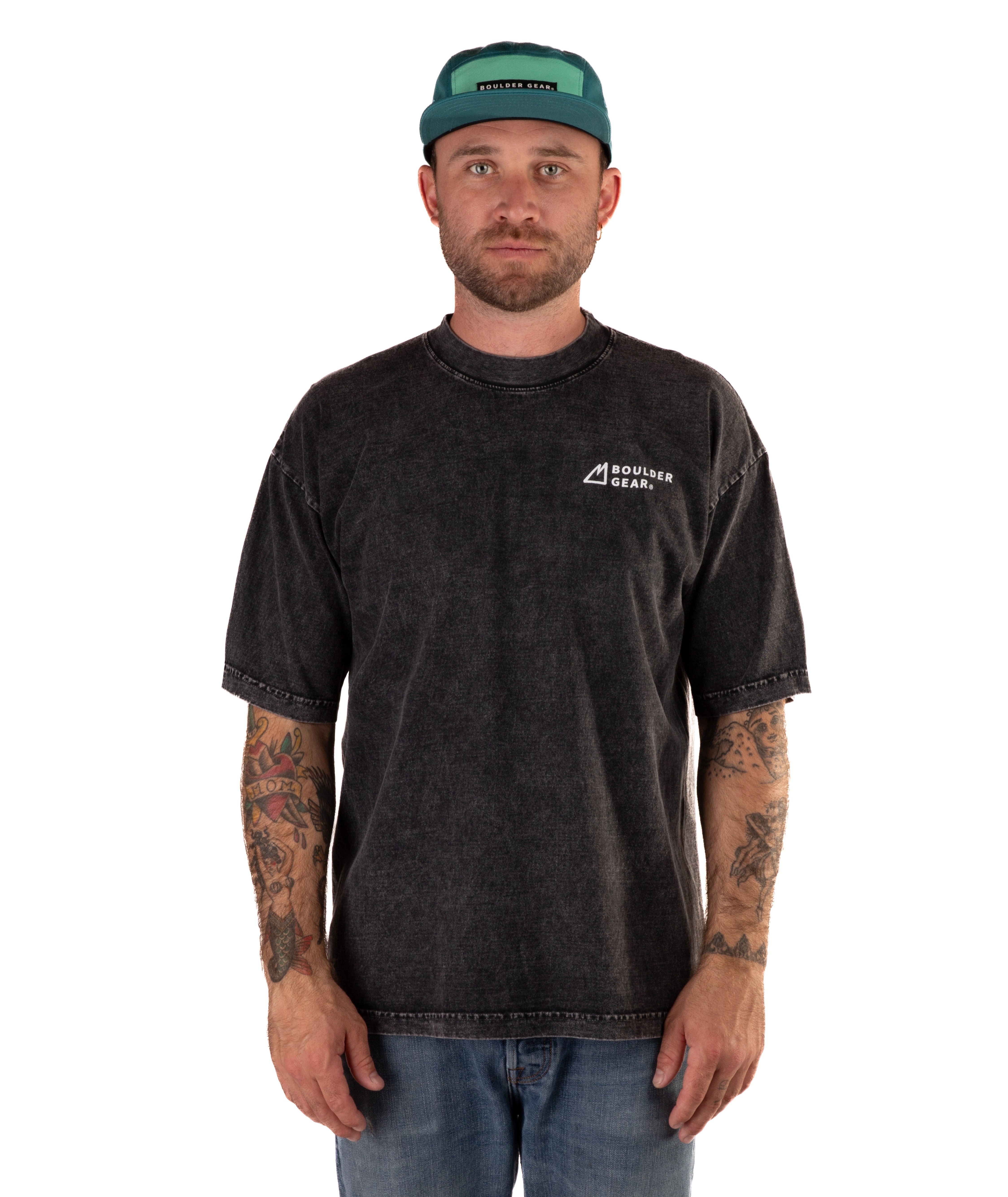 Man wearing a faded black t-shirt with a logo and a green cap on a white background