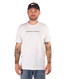 Man wearing a white t-shirt with text and a black cap on a white background