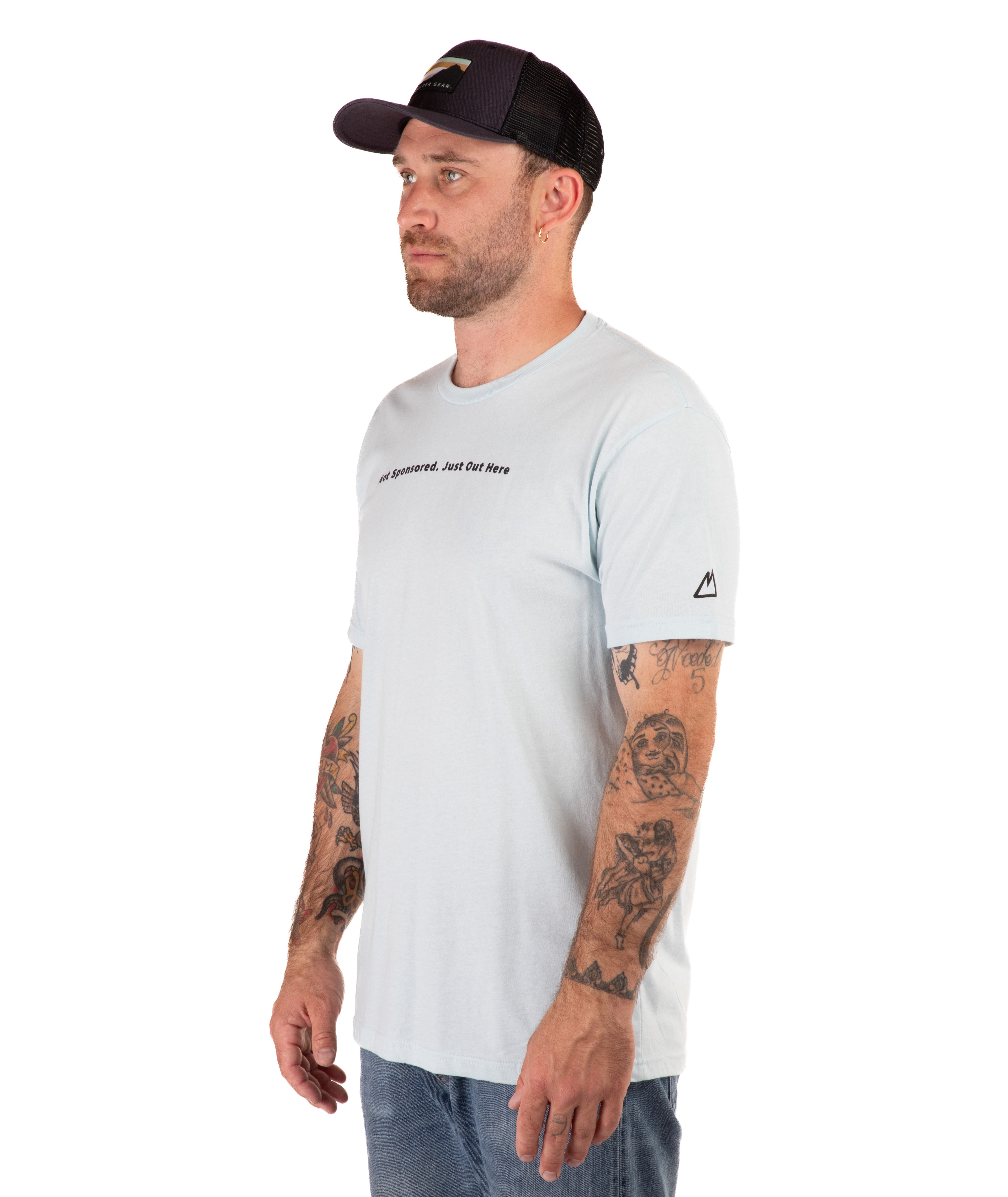 Man wearing a light blue t-shirt with text and a black cap on a white background