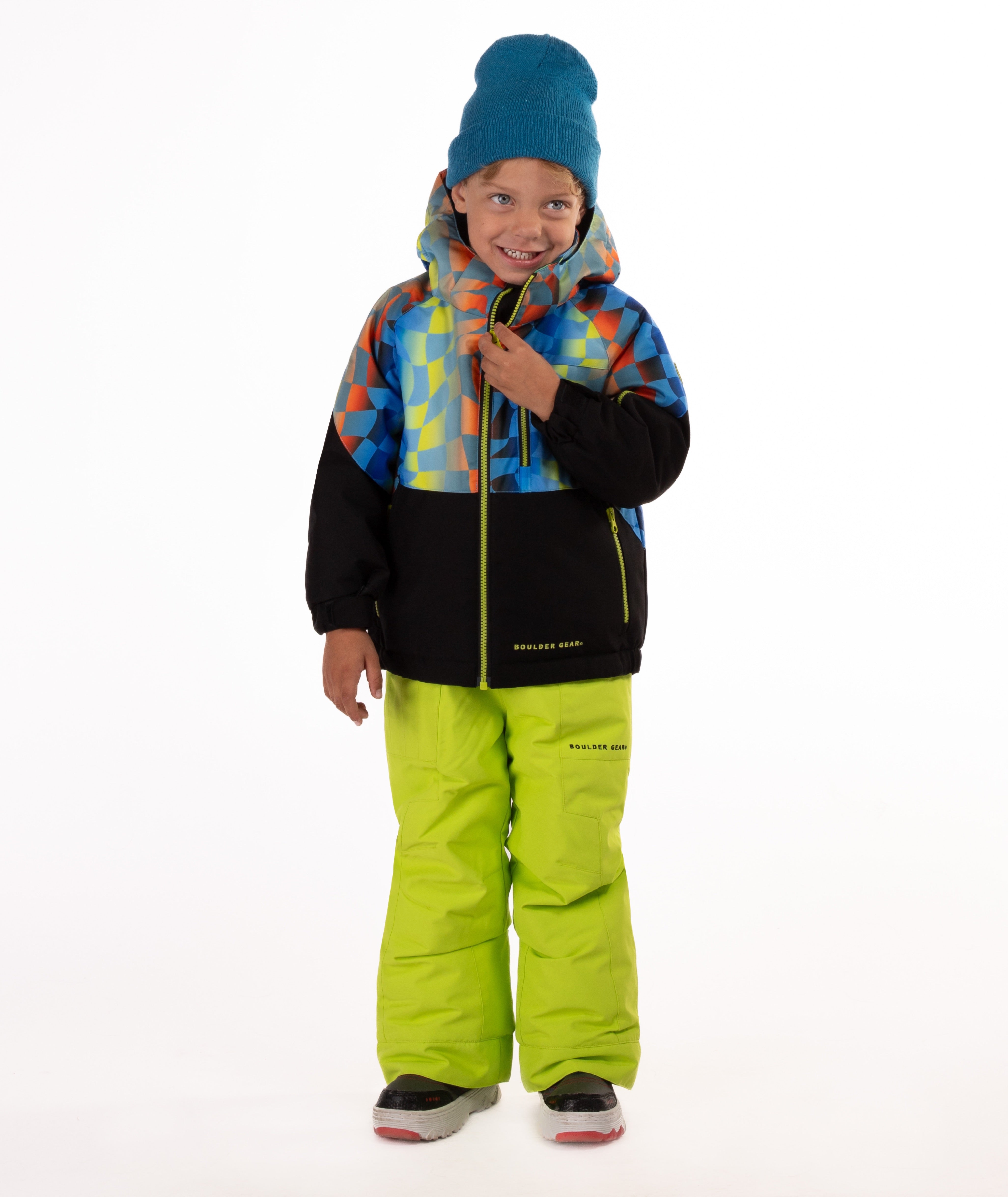 Child wearing a two-tone jacket with a geometric multi-color print on the top and black on the bottom of the jacket