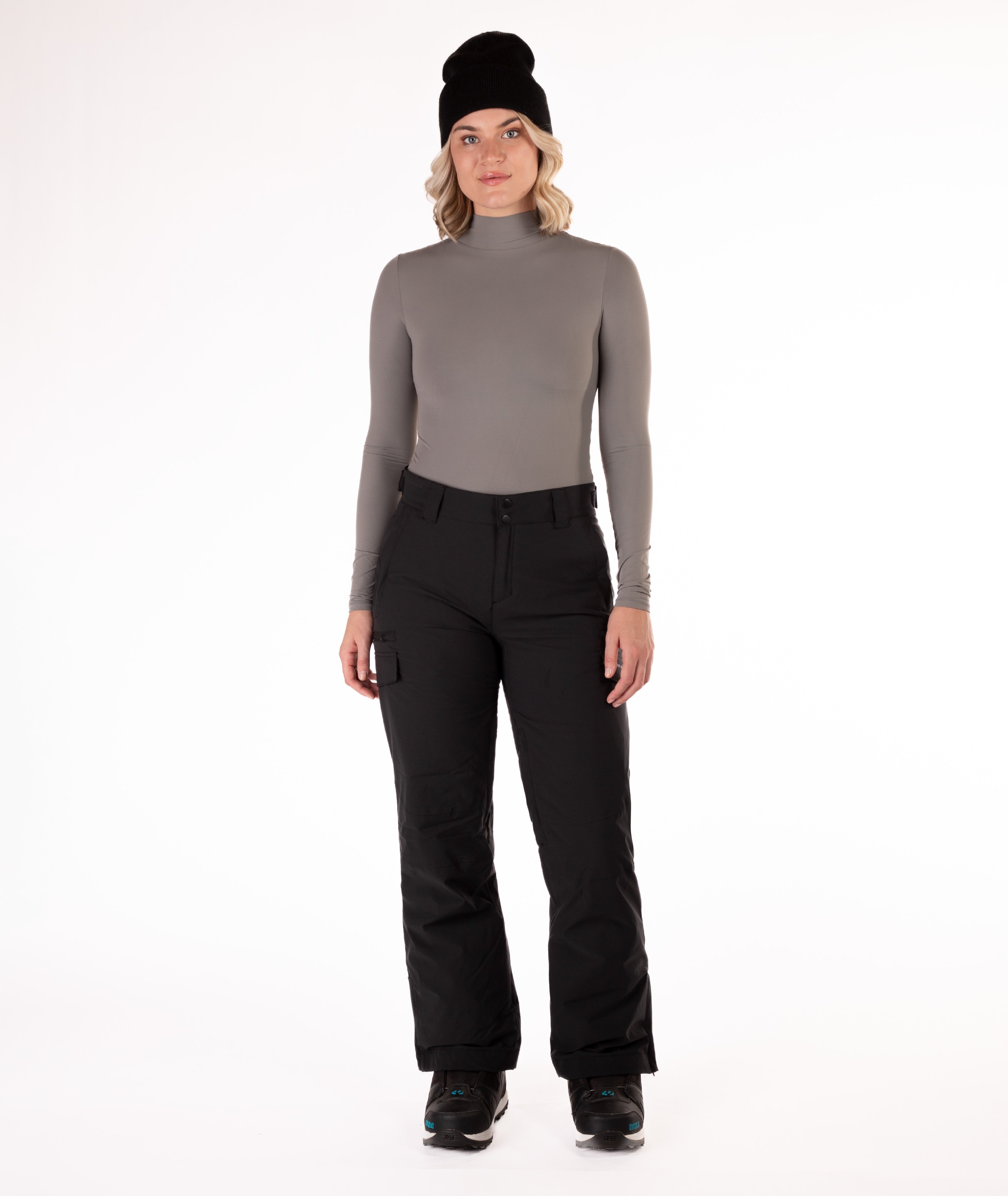 Person wearing a gray long-sleeve top and black snow pants on a white background