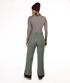 back of person wearing a gray long-sleeve top and green snow pants on a white background