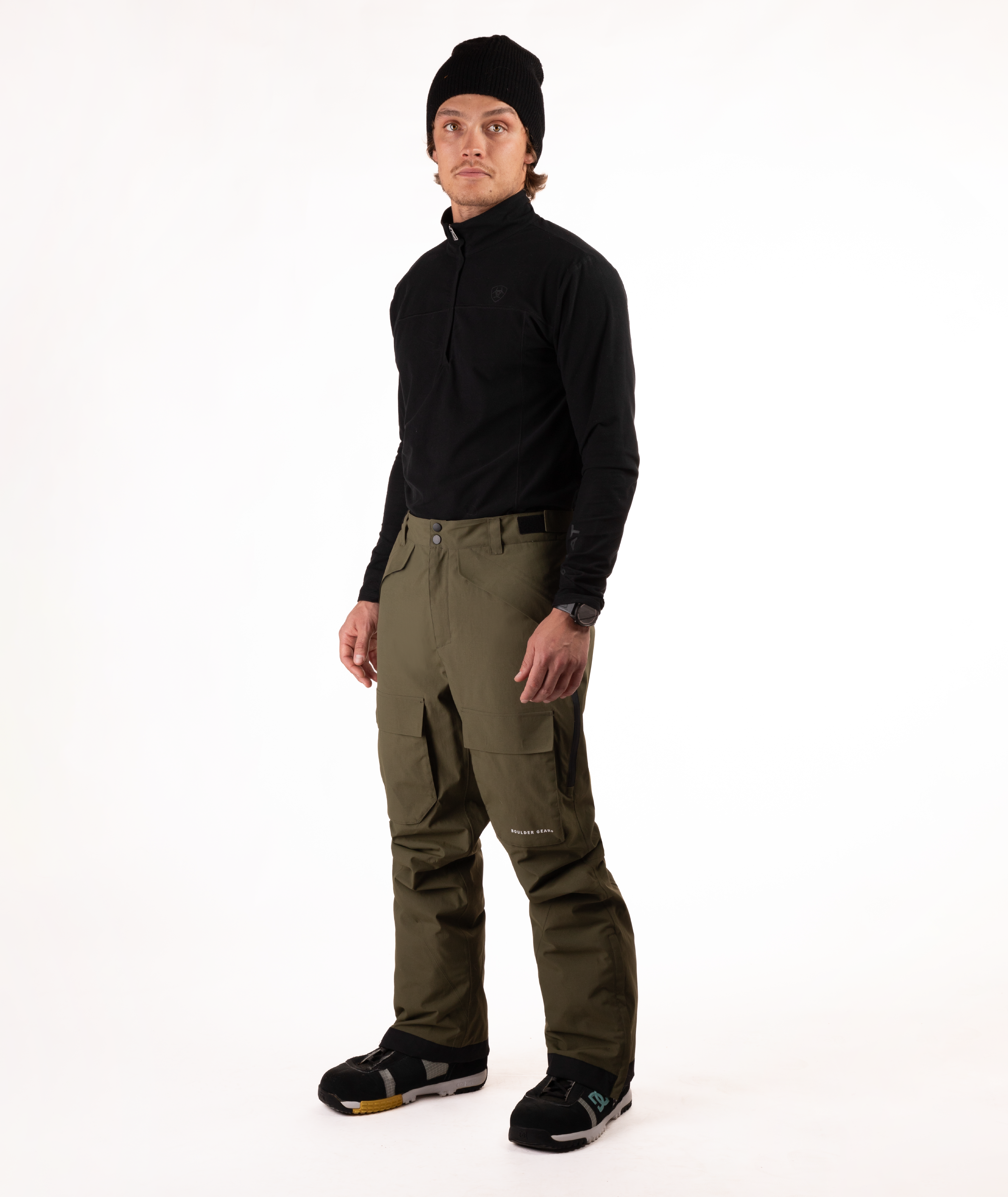 Person wearing a black shirt and green snow pants on a white background