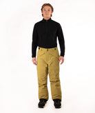A man modeling a black long-sleeve quarter-zip fleece and mustard yellow snow pants with black snow boots, standing against a solid white studio background.