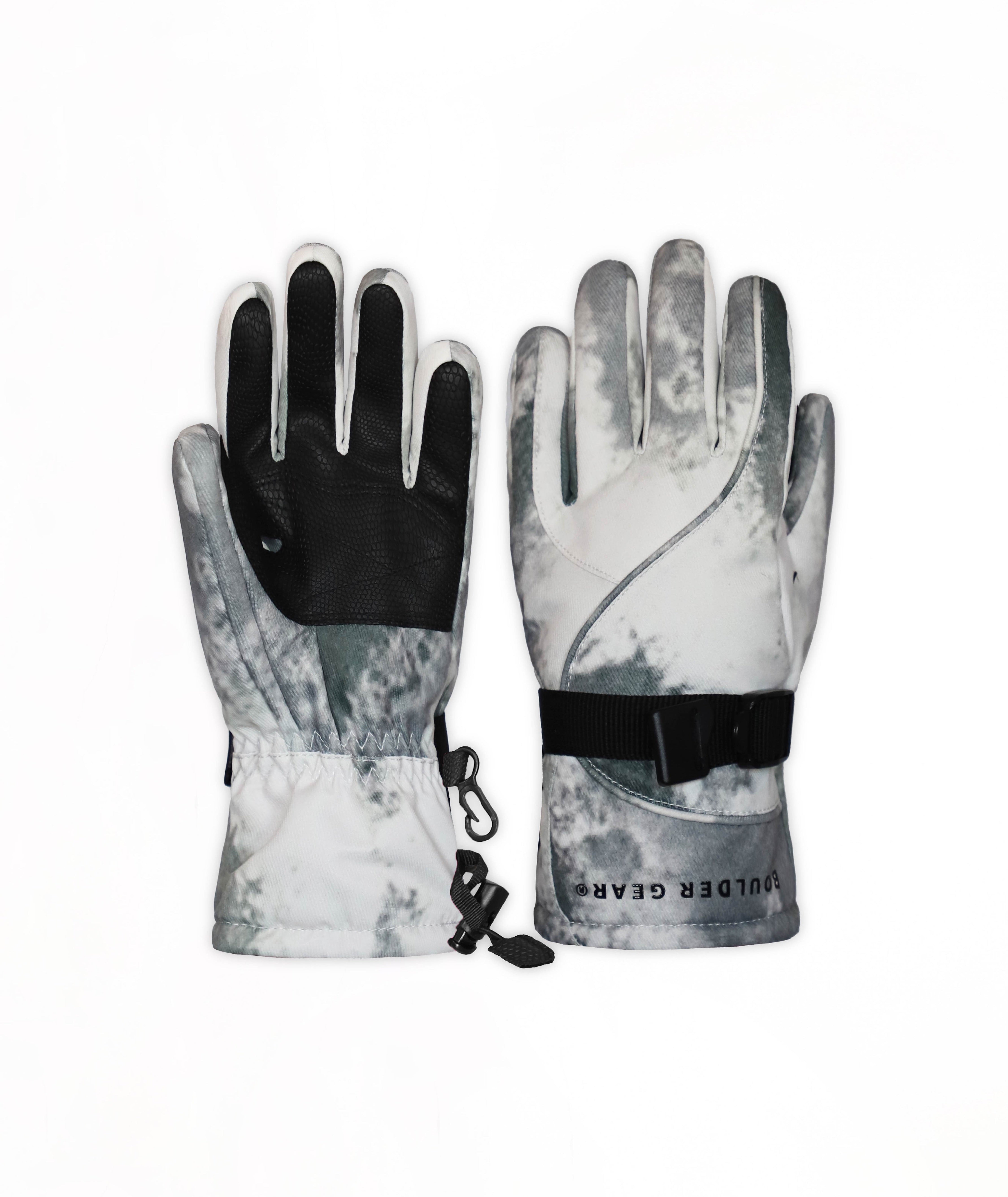 A pair of winter gloves with a gray and white camouflage pattern, featuring black palms and a black adjustable wrist strap with a buckle.