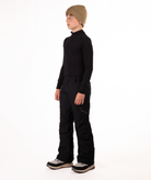 youth boy wearing a black long-sleeve shirt and black snow pants on a white background