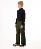 youth boy wearing a black long-sleeve shirt and green snow pants on a white background