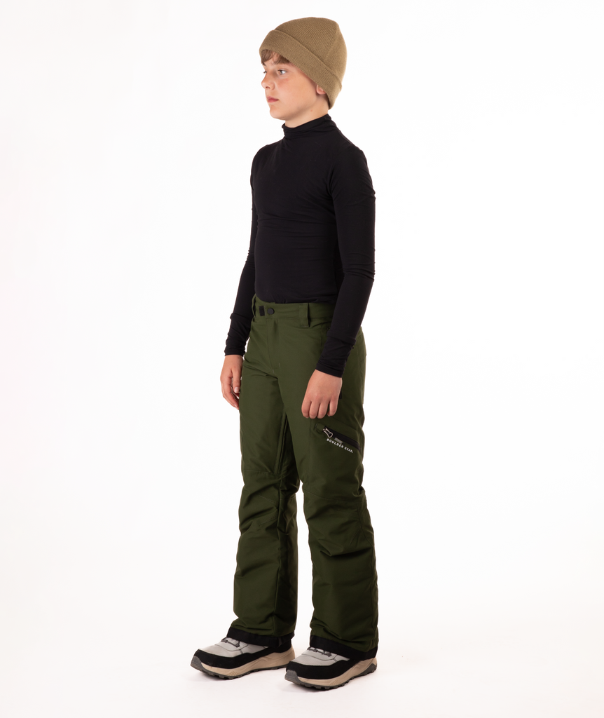 youth boy wearing a black long-sleeve shirt and green snow pants on a white background