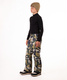 youth boy wearing a black long-sleeve shirt and camouflage snow pants on a white background