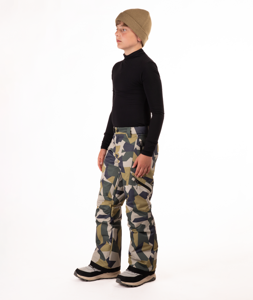 youth boy wearing a black long-sleeve shirt and camouflage snow pants on a white background